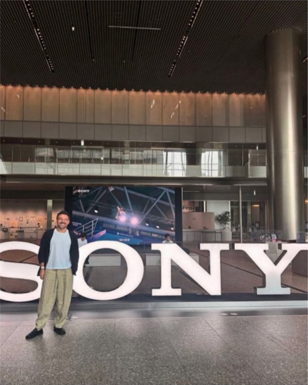 A man standing in front of the SONY letters in the lobby of Sony Group headquarters