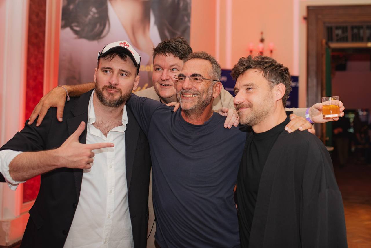Four men posing together at an evening event