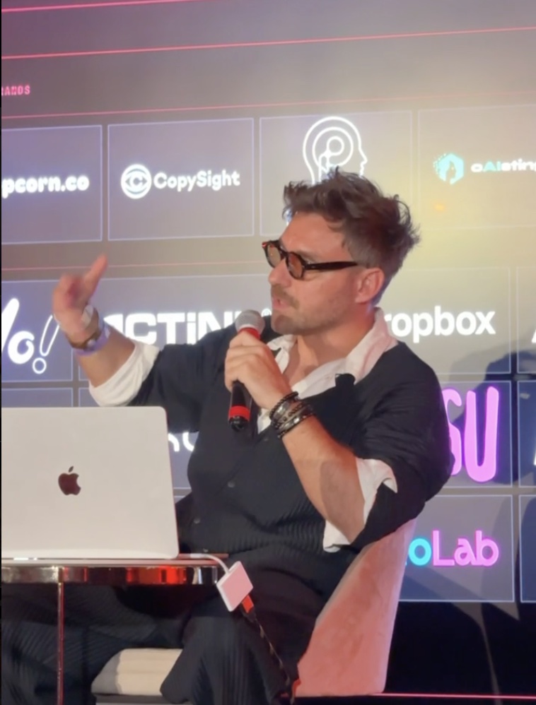 Artem Petrov speaks into a microphone on stage, with the CopySight logo on the screen behind him